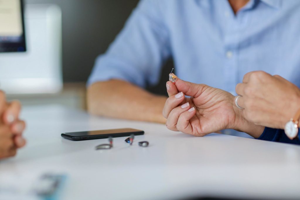 Person holding invisible hearing aid